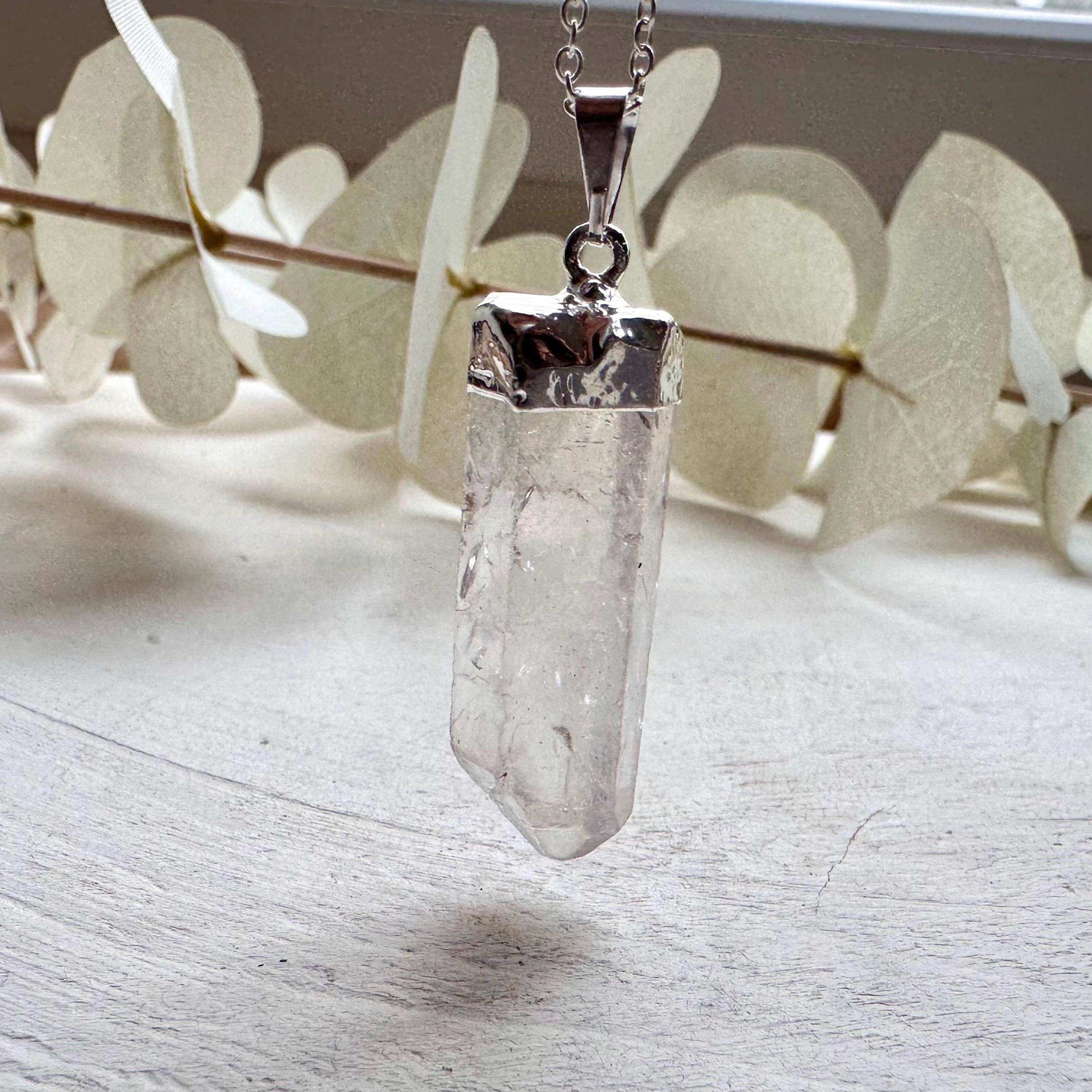 Close-up of a crystal pendant necklace showcasing minimalist design and natural elegance.